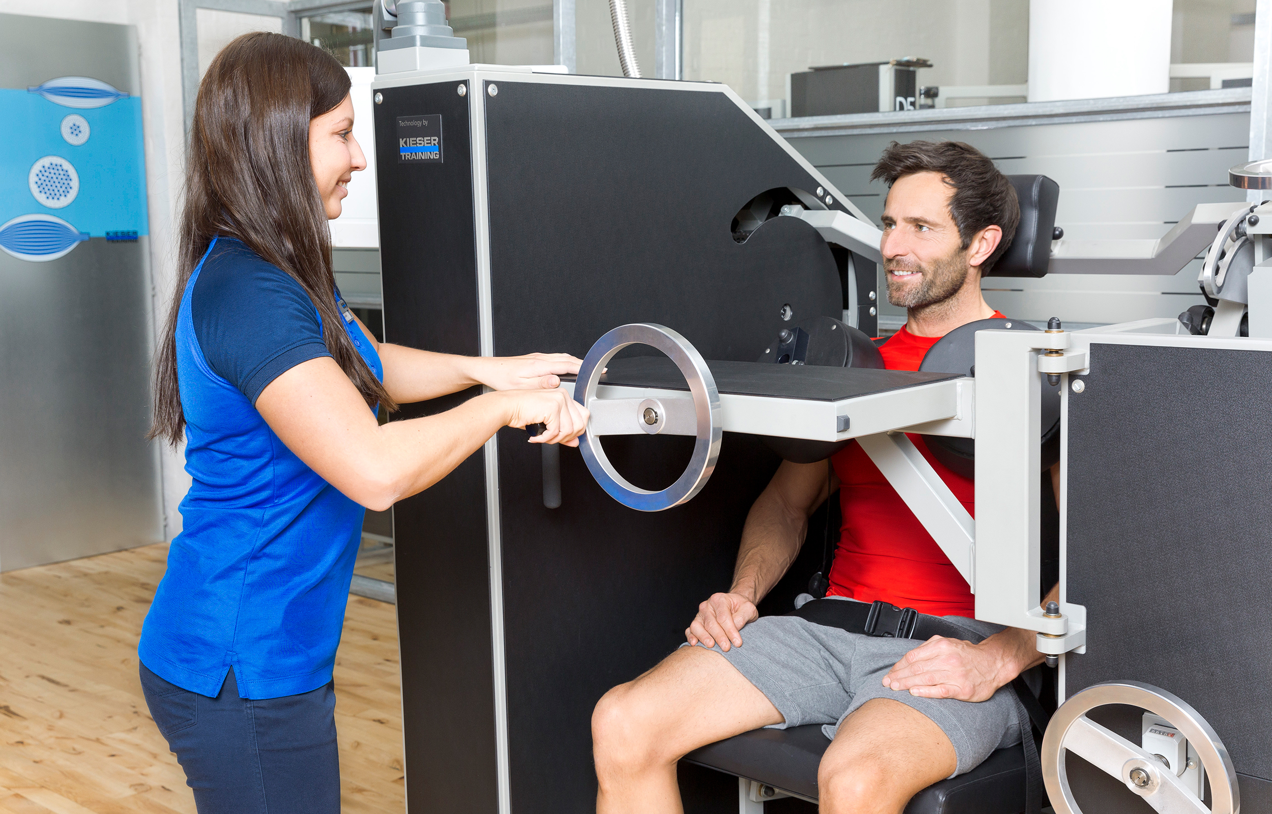 Das Bild zeigt ein Kunde von Kieser Training, der in Begleitung einer Instruktorin an der CE-Rückenmaschine trainiert.